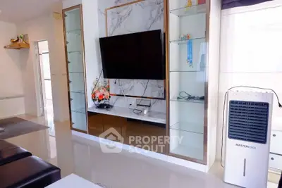 Modern living room with sleek TV unit and air cooler, featuring elegant decor and glossy flooring.