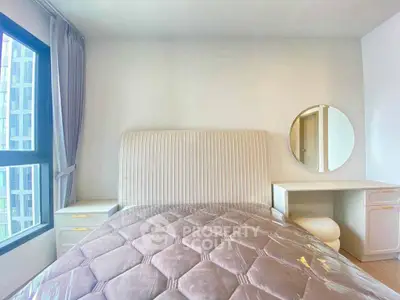 Bright bedroom with modern furniture and large window view.