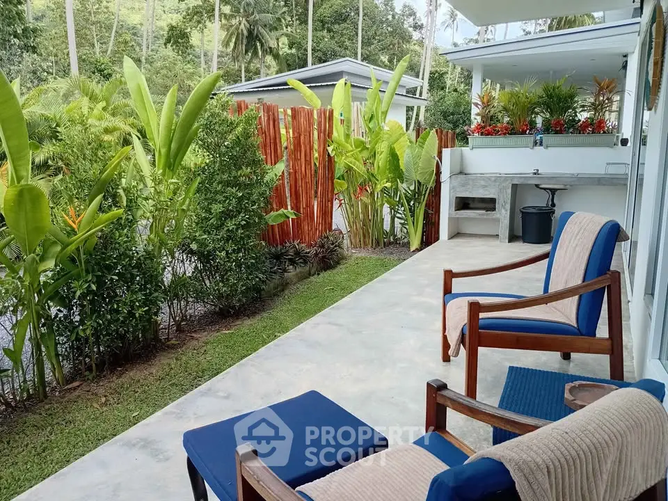 Charming outdoor patio with lush greenery and cozy seating area, perfect for relaxation and entertaining.