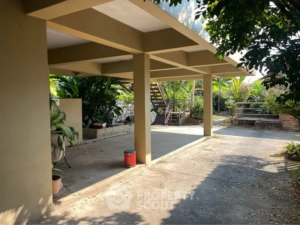 Spacious outdoor area with covered parking and lush greenery