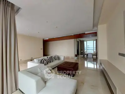 Spacious modern living room with elegant decor and large windows offering natural light.