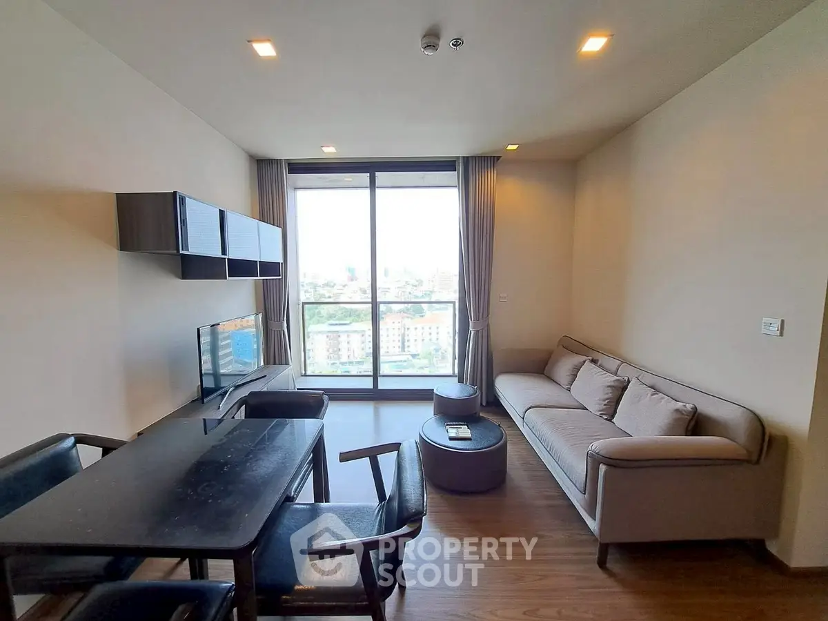 Modern living room with city view, stylish furniture, and natural light.