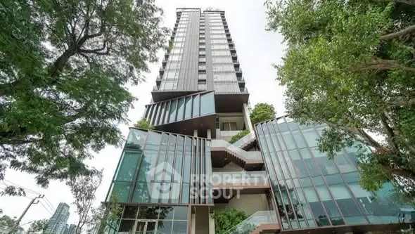 Stunning modern high-rise building with unique architectural design and lush greenery.