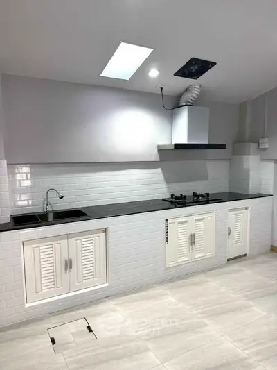 Modern kitchen with sleek white cabinetry and gas stove
