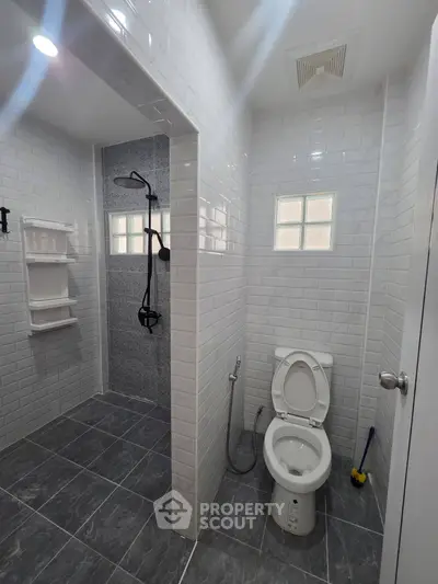 Modern bathroom with sleek shower and toilet in stylish tiled design
