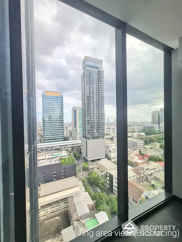 Expansive cityscape view from a high-rise living area with floor-to-ceiling windows, showcasing a dynamic urban panorama and abundant natural light, perfect for modern living.