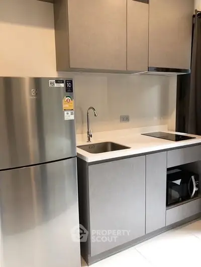 Modern kitchen with sleek cabinetry, stainless steel fridge, and built-in appliances.
