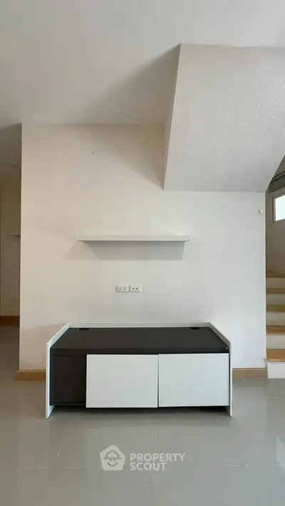 Modern minimalist interior with sleek furniture and staircase, perfect for contemporary living.