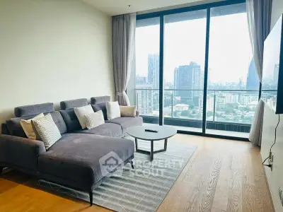 Modern living room with large windows offering stunning city views and stylish gray furniture.