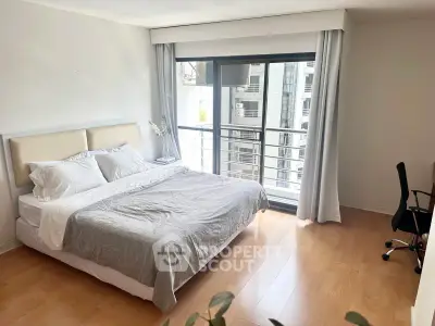 Spacious bedroom with large window and modern decor in urban apartment