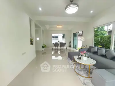 Spacious modern living room with elegant decor and large windows offering natural light.