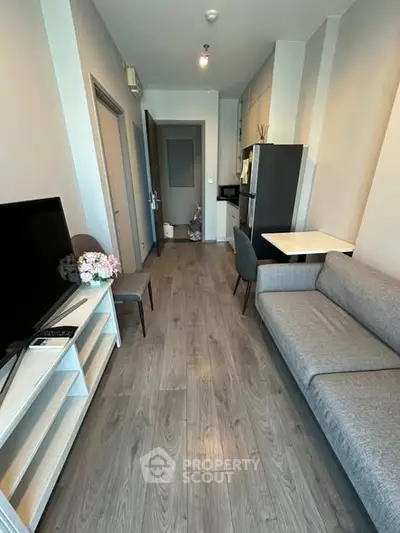 Modern living room with sleek furniture and wood flooring in a cozy apartment.