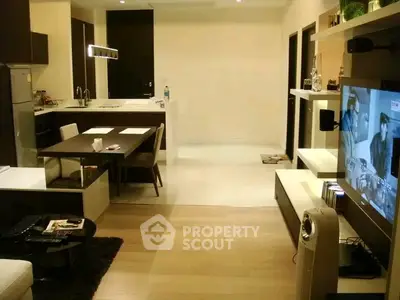 Modern open-layout living room with stylish furniture and integrated kitchen area.