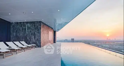 Luxurious rooftop infinity pool with stunning sunset view and modern lounge chairs.