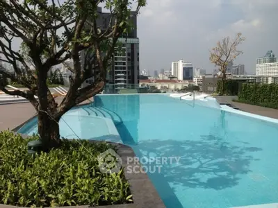 Luxurious rooftop pool with stunning city skyline views and lush greenery.