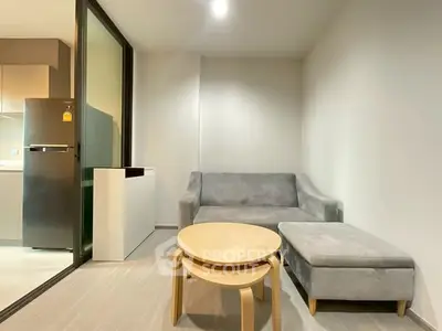Modern living room with sleek furniture and adjacent kitchen area
