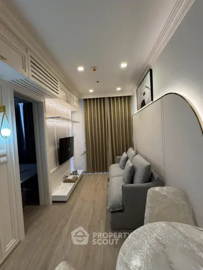 Modern living room with sleek design, featuring a cozy sofa, wall-mounted TV, and elegant lighting.