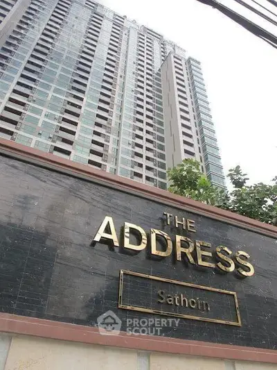 Modern high-rise building exterior with prominent signage at The Address Sathorn.