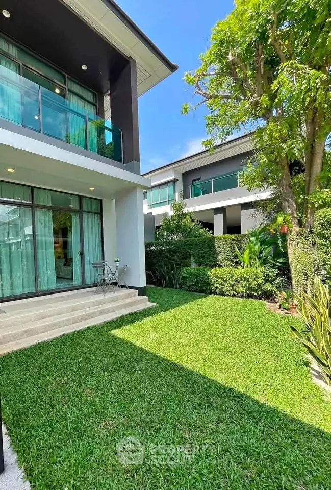 Modern home exterior with lush garden and large windows, perfect for natural light lovers.