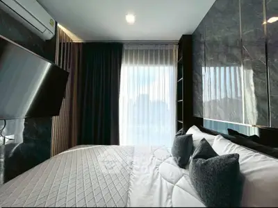 Luxurious modern bedroom with elegant decor and large window view.