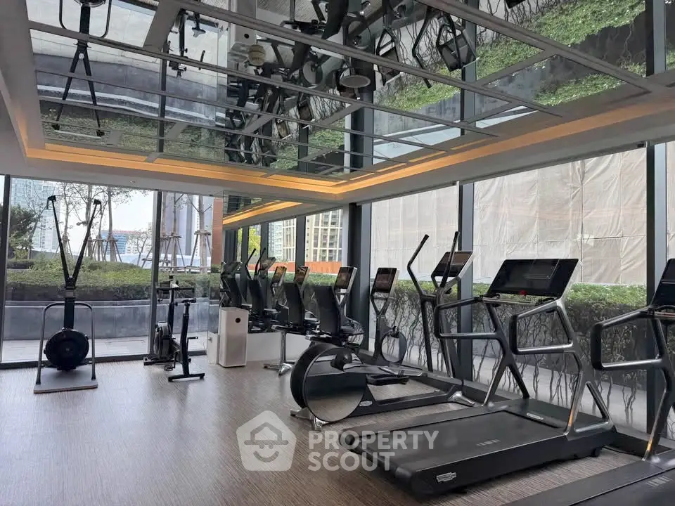 Modern gym with state-of-the-art equipment and large windows offering a scenic view.