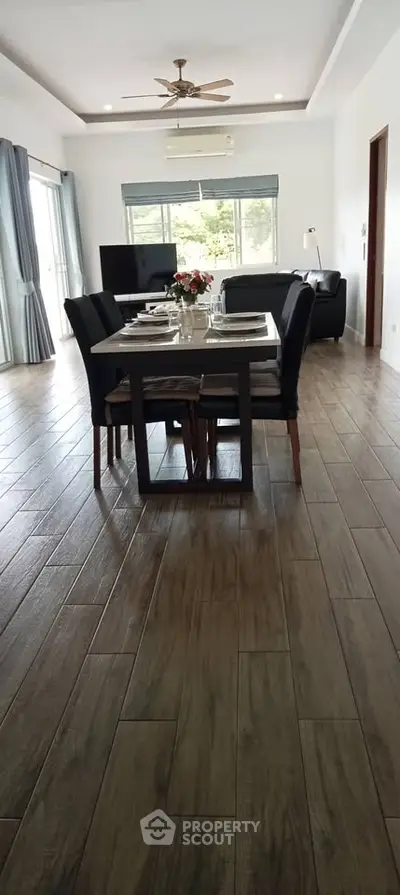 Spacious dining area with elegant wooden flooring and modern decor