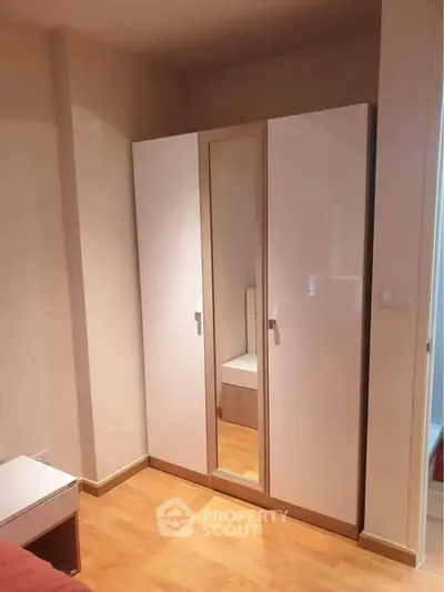 Modern bedroom with sleek wardrobe and wooden flooring