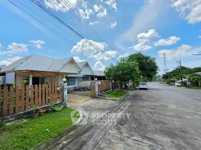 Charming suburban house with driveway and lush greenery on a sunny day.