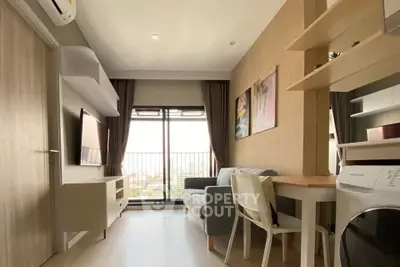 Modern living room with balcony view, featuring sleek furniture and natural light.