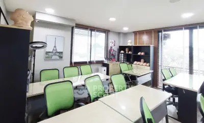 Modern study room with green chairs and ample natural light, perfect for creative work or meetings.