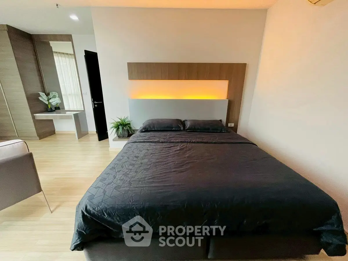 Modern bedroom with stylish lighting and sleek design, perfect for urban living.