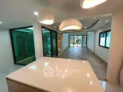 Spacious modern living room with open layout and elegant lighting, featuring large windows and stylish flooring.