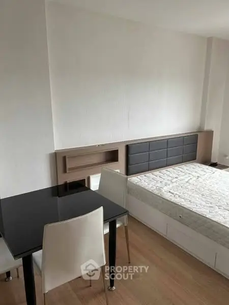 Modern minimalist bedroom with sleek furniture and wooden flooring