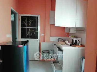 Charming kitchen with modern appliances and vibrant wall color, perfect for culinary enthusiasts.