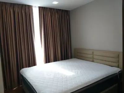 Cozy bedroom with elegant curtains and comfortable bed in modern apartment.