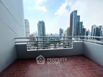 Spacious balcony with stunning city skyline view in modern high-rise apartment.