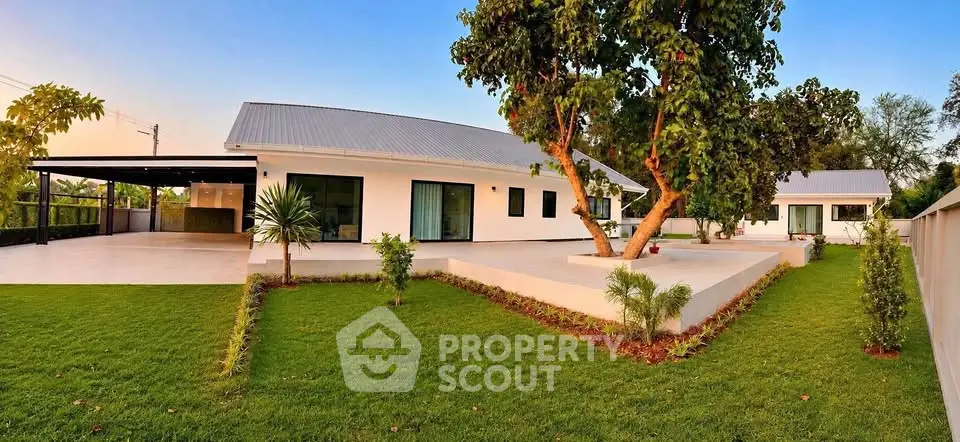 Modern single-story home with lush green lawn and spacious patio, perfect for family living.