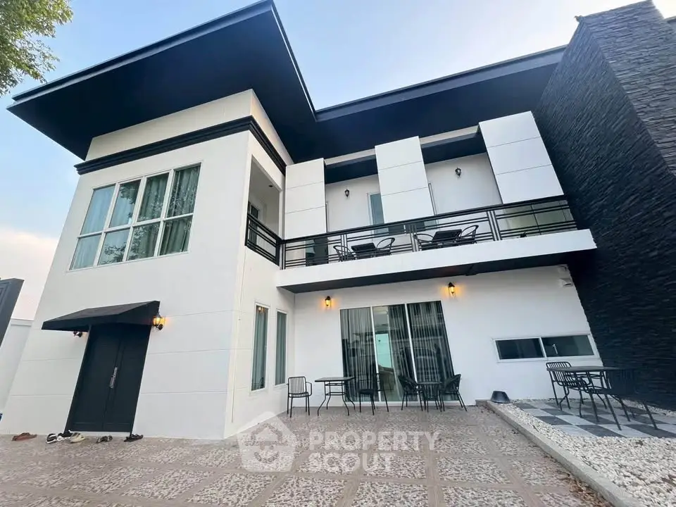 Modern two-story house with spacious patio and stylish exterior design.