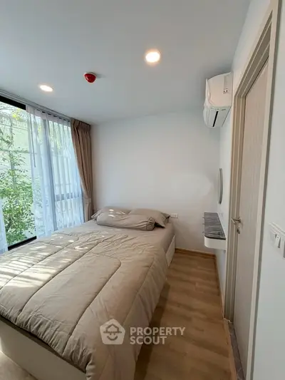 Cozy bedroom with large window and modern decor in a stylish apartment.
