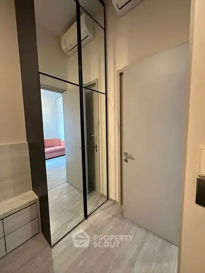 Modern apartment interior with mirrored closet and air conditioning, showcasing sleek design and functionality.