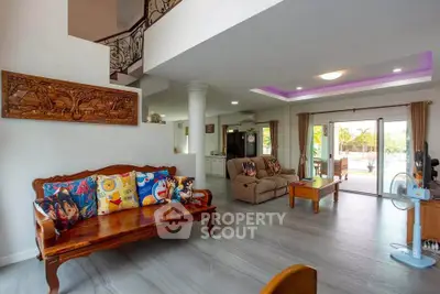 Spacious living room with elegant decor and large windows offering natural light and garden view.