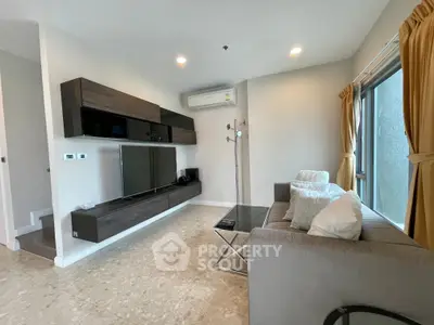 Modern living room with sleek furniture and large window, perfect for relaxation and entertainment.