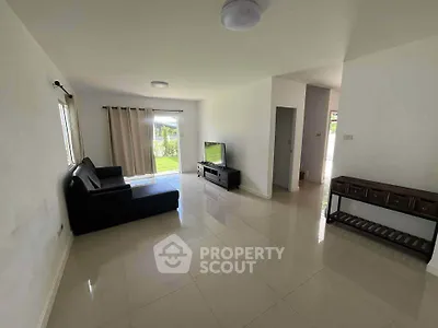 Spacious living room with sleek tile flooring and modern furniture, ideal for family gatherings.