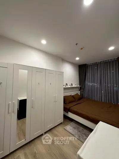 Modern bedroom with sleek design, featuring a spacious wardrobe and cozy bed, perfect for urban living.