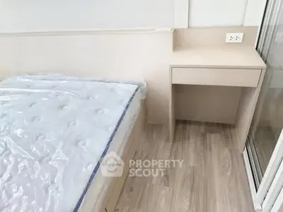 Modern bedroom with sleek design and built-in desk, featuring light wood flooring and a comfortable bed.