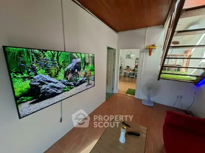 Cozy living room with wall-mounted TV and modern staircase