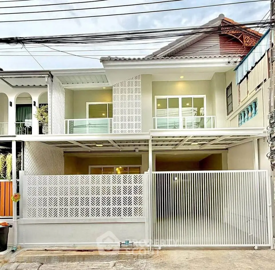 Modern townhouse exterior with sleek design and spacious balcony in urban setting.