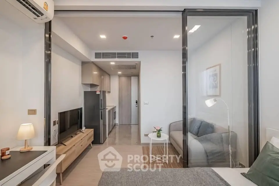 Modern studio apartment with open layout, featuring sleek kitchen and cozy living area.