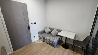 Cozy modern living room with compact sofa and dining table, perfect for urban living.