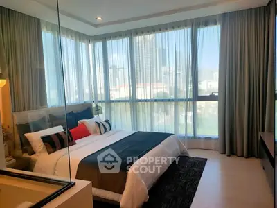 Luxurious bedroom with floor-to-ceiling windows offering stunning city views.